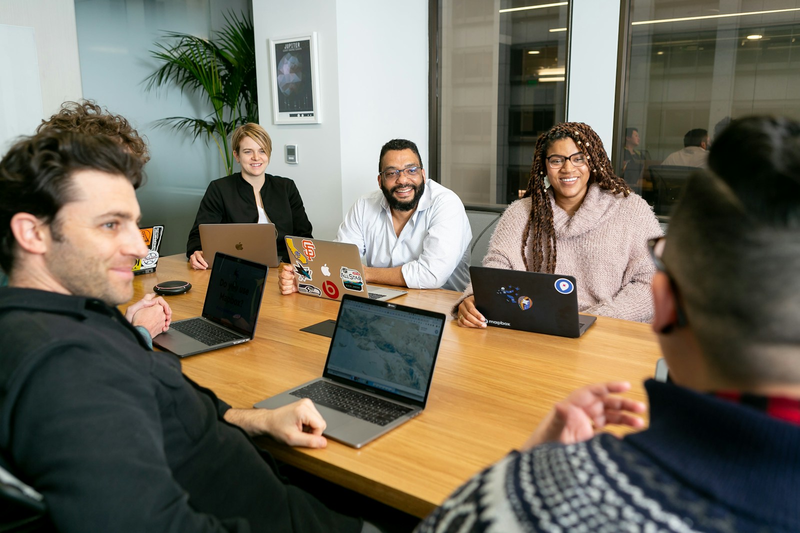 Cloud strategy meeting: IT leadership reviewing workload portfolio across laptops